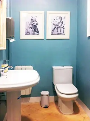 a blue bathroom with a toilet and a sink at Casa del Mediterraneo in Barcelona