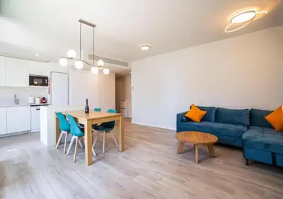 a living room with a blue couch and a table at Forum Casa Barcelona in Sant Adria de Besos