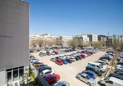 a parking lot full of cars in a city at Forum Casa Barcelona in Sant Adria de Besos