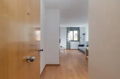 an open door to a living room with a couch at GuestReady - Bright home near Montjuïc in Barcelona