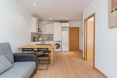 a living room and kitchen with a table and chairs at GuestReady - Bright home near Montjuïc in Barcelona
