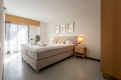 a white bedroom with a large bed and a window at CATERINA Sagrera in Barcelona