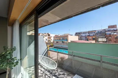 a balcony with a chair and a view of a city at CATERINA Sagrera in Barcelona