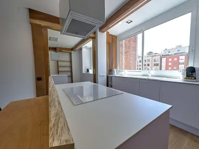 a kitchen with a white counter and a large window at Stay U-nique Apartment Padilla in Barcelona