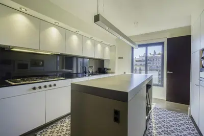a large kitchen with white cabinets and a large window at Ola Living Paseo de Gracia in Barcelona
