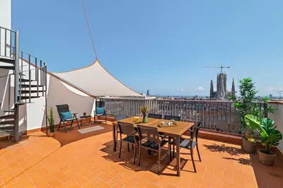 a patio with a table and chairs on a balcony at Tendency Apartments Sagrada Familia Penthouse in Barcelona