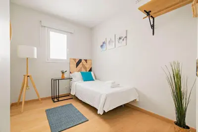 a white bedroom with a bed and a table at Tendency Apartments Sagrada Familia Penthouse in Barcelona
