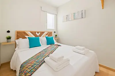 a bedroom with a white bed with towels on it at Tendency Apartments Sagrada Familia Penthouse in Barcelona