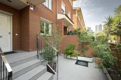 a brick house with a balcony with plants on it at Apartamento Luxury Gran Via 2 in Hospitalet de Llobregat