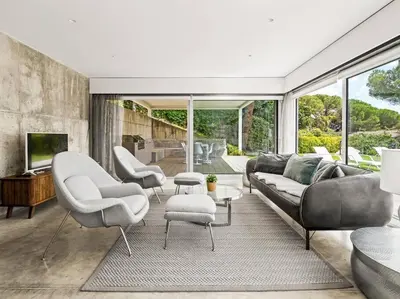 a living room with a couch and chairs and a tv at Design villa sea views and lap pool in Cabrils