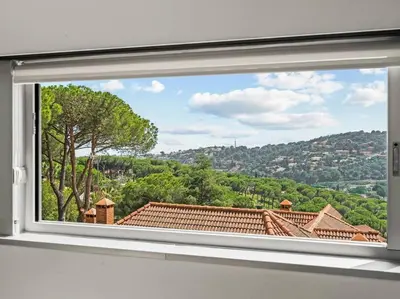 a window with a view of a city at Design villa sea views and lap pool in Cabrils