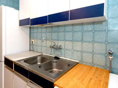 a kitchen with a stainless steel sink and blue tiles at Apartment Els Pins by Interhome in Sant Vicenç de Montalt
