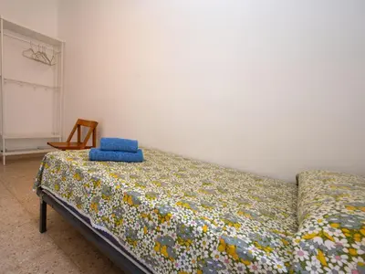 a bedroom with a bed with a blue pillow on it at Apartment Els Pins by Interhome in Sant Vicenç de Montalt