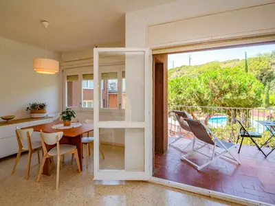 a kitchen and dining room with a table and chairs at Apartment Els Pins by Interhome in Sant Vicenç de Montalt