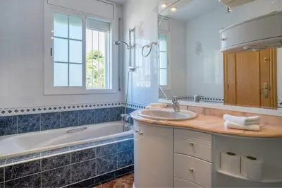 a bathroom with a tub and a sink and a bath tub at Basketball court, pool, BBQ, gardens, seaviews in San Pol de Mar