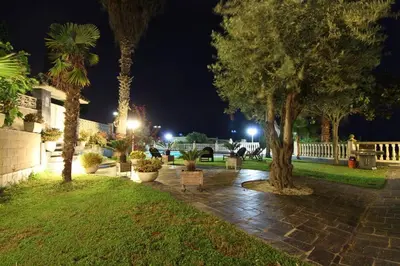 a park at night with palm trees and a sidewalk at Basketball court, pool, BBQ, gardens, seaviews in San Pol de Mar