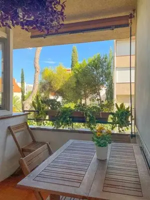a balcony with a table and a window with plants at Apartment Coloma Piscina y Parking Hostem in Vilanova i la Geltrú