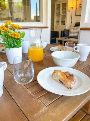 a table with a plate of food and orange juice at Apartment Coloma Piscina y Parking Hostem in Vilanova i la Geltrú