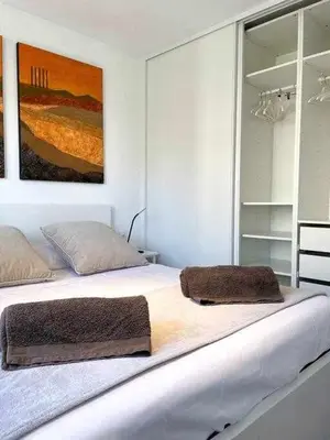 a white bedroom with a large bed with two pillows at Apartment Coloma Piscina y Parking Hostem in Vilanova i la Geltrú