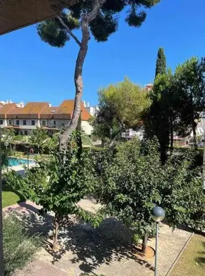 a view of a garden with trees and a building at Apartment Coloma Piscina y Parking Hostem in Vilanova i la Geltrú