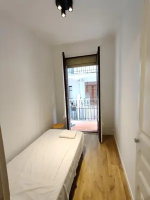 a bedroom with a bed and a sliding glass door at Céntrico apartamento in Barcelona