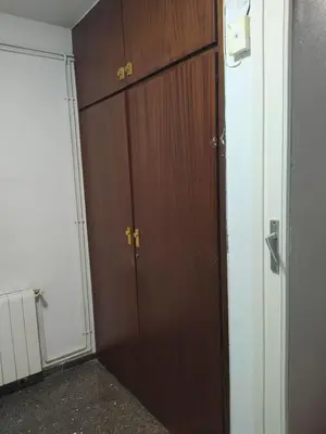 a large wooden closet with two doors in a room at Primera línea de mar y piscina a 20 minutos de Barcelona in Premiá de Mar