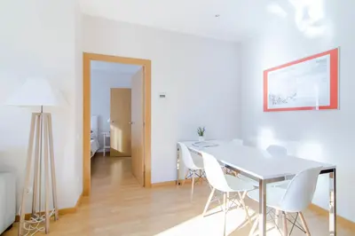 a dining room with a white table and white chairs at Pelayo Deluxe Apartments in Barcelona