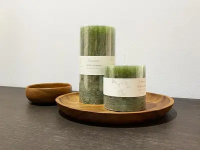 two candles are sitting on a wooden plate at Barcelona Beach Breeze in Barcelona