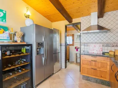 a kitchen with a stainless steel refrigerator and wooden ceilings at Finca Montnegre Suites and Spa in Sant Iscle de Vallalta