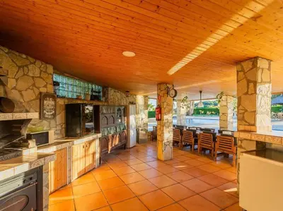 a large kitchen with a table and chairs in it at Finca Montnegre Suites and Spa in Sant Iscle de Vallalta