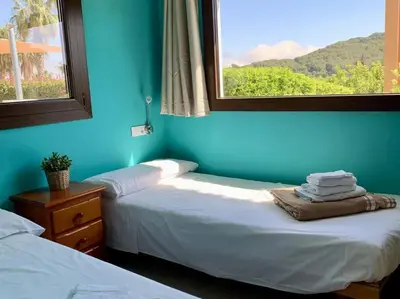 two beds in a room with blue walls and a window at Finca Montnegre Suites and Spa in Sant Iscle de Vallalta