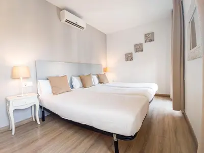 a bedroom with a large white bed and a night stand at Canela Homes BARCELONA BALMES in Barcelona