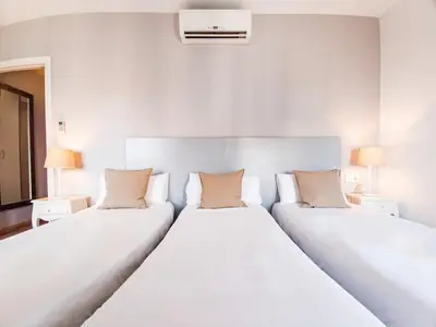 two white beds in a room with two lamps at Canela Homes BARCELONA BALMES in Barcelona