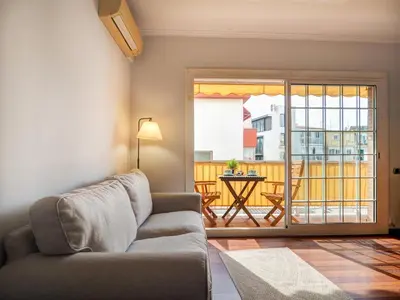 a living room with a couch and a balcony at The Beach Apartment by Hello Homes Sitges in Sitges