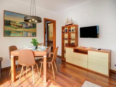 a dining room with a table with chairs and a tv at The Beach Apartment by Hello Homes Sitges in Sitges