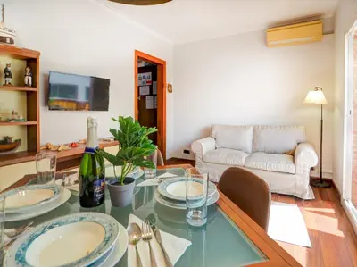 a living room with a table and a couch at The Beach Apartment by Hello Homes Sitges in Sitges