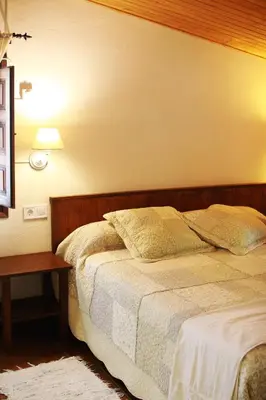 a bedroom with a bed and a table with a lamp at El Celler de la Guàrdia in Montserrat