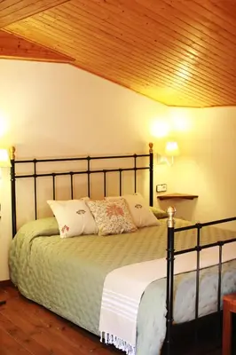 a bedroom with a bed with a wooden ceiling at El Celler de la Guàrdia in Montserrat