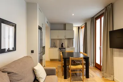 a living room and kitchen with a table and a couch at Uma Suites Barceloneta Beach in Barcelona