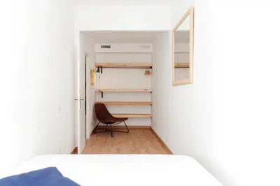 a bedroom with a bed and a mirror and a chair at My Address in Sant Antoni in Barcelona