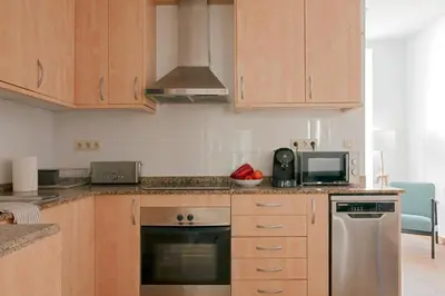 a kitchen with wooden cabinets and a stove top oven at My Address in Sant Antoni in Barcelona