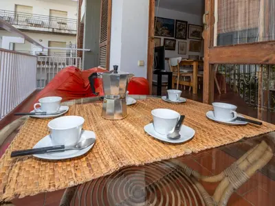 a table with cups and saucers and a coffee pot at Apartment Zodiak by Interhome in Pineda de Mar