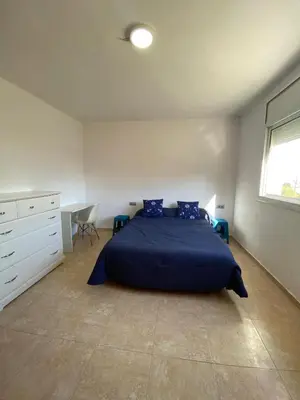 a bedroom with a bed and a desk and a window at CAN TRULLEN CHALET CALAFELL in Calafell