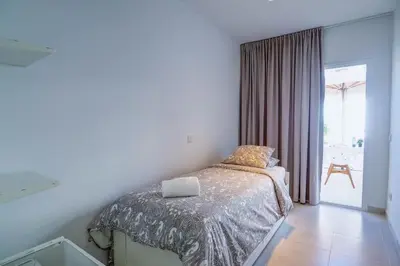 a bedroom with a bed and a sliding glass door at Camelot Apartment by Hello Homes Sitges in Sitges