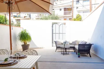 a patio with a table and chairs and an umbrella at Camelot Apartment by Hello Homes Sitges in Sitges