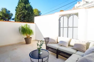 a patio with a couch and a table at Camelot Apartment by Hello Homes Sitges in Sitges