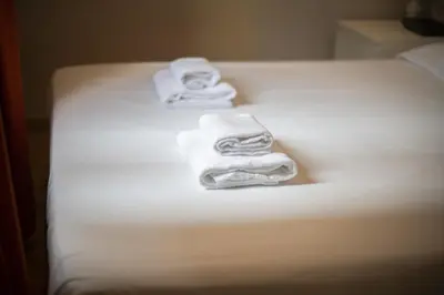 three towels sitting on top of a bed at Catalunya Casas 2 bed apartment in Barceloneta steps from the beach in Barcelona