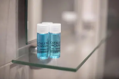 two bottles of water sitting on a glass shelf at Catalunya Casas 2 bed apartment in Barceloneta steps from the beach in Barcelona