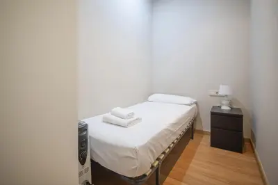 a small bed with white sheets and towels on it at Catalunya Casas 2 bed apartment in Barceloneta steps from the beach in Barcelona