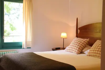 a bedroom with a bed and a window at Hostal l´Ou de Reig in Montseny